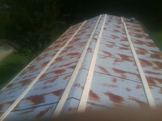 Rusted metal roof panels with new wood purlins before replacement — Storm Damage Roof Repair in Swampscott by Roofing Brothers
